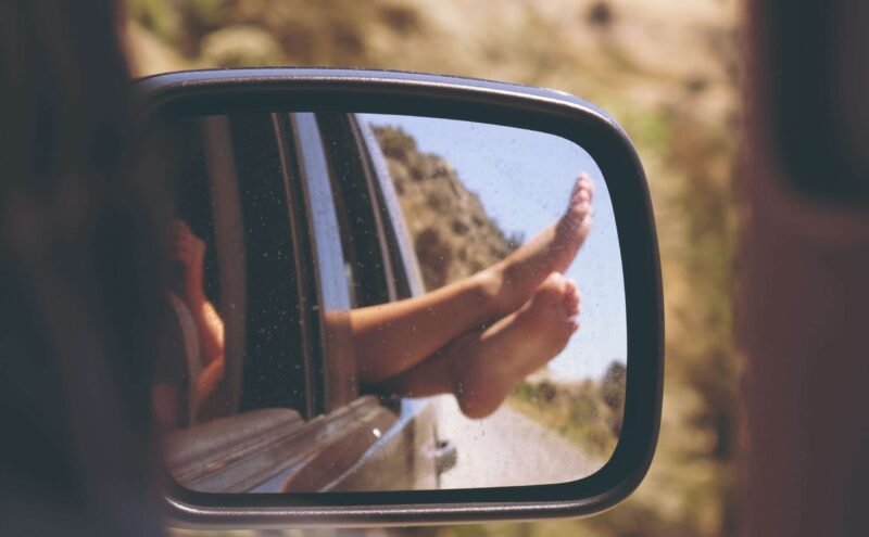 person's leg resting on vehicle window